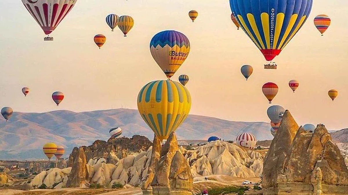 Hot air balloons over the fairy chimneys of Cappadocia on a trip from Istanbul, Türkiye